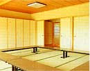 畳張りの室内に、囲むように机が置かれている宿泊室(大)の写真