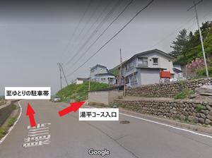 道路上に示されたゆとりの駐車帯へ至る前方のルートと、石垣の横を通る右横への湯平コースの入り口のルート写真