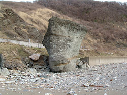 山を背景に、大きな巨岩がある景色の写真