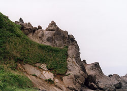 とがった岩が連なっているような、斜めの崖の景色の写真