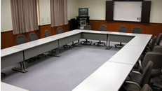会議向けに囲むように長机が並べられた研修室の写真