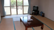 和室でテーブルとポットとテレビが置いてある宿泊室（中）かえでの写真